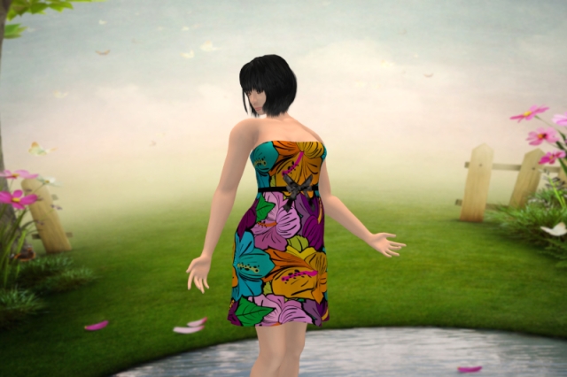 Self-portrait in a strapless, almost knee-length dress with colourful flower print and a black ribbon around the waist; the slightly blurry background shows a meadow, fences and pink flowers on both sides and a pond at the bottom