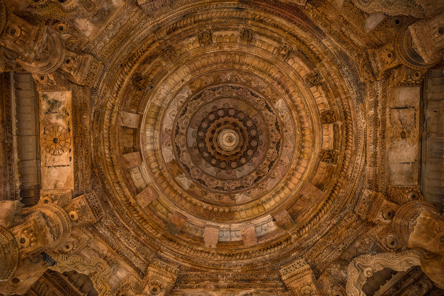 The carved ceiling of the Sabha Mandap at Modhera Sun Temple. The temple is aligned with sunrise on solstices and equinoxes, and with the passage of the Sun overhead during the summer solstice. During sunrise on the spring and autumn equinox, it is believed rays of light would pass through the Sabha Mandap and illuminate a sacred idol in the temple complex beyond.