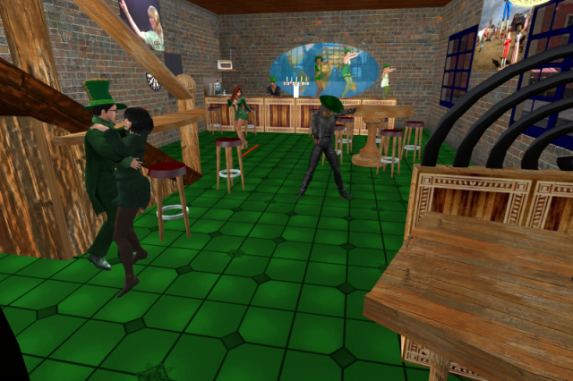 Interior view of the virtual Irish pub Gulliver's. Fitting the theme, the floor is green. To the left, Juno and I am dancing. The grid owners and several guests can be seen, too, including two ladies dancing on the bar in the background in front of a world map. Everyone is dressed for the occasion, wearing a lot of green.